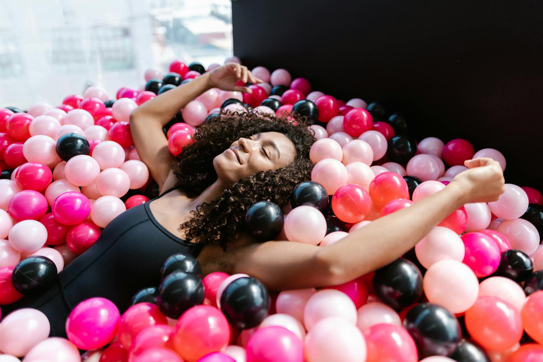 woman lying on plastic balls