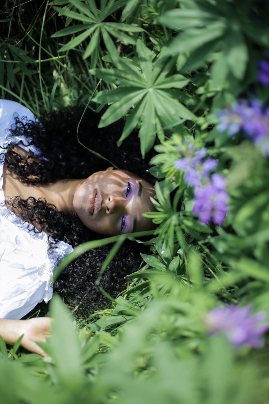 woman in white shirt lying on green grass field