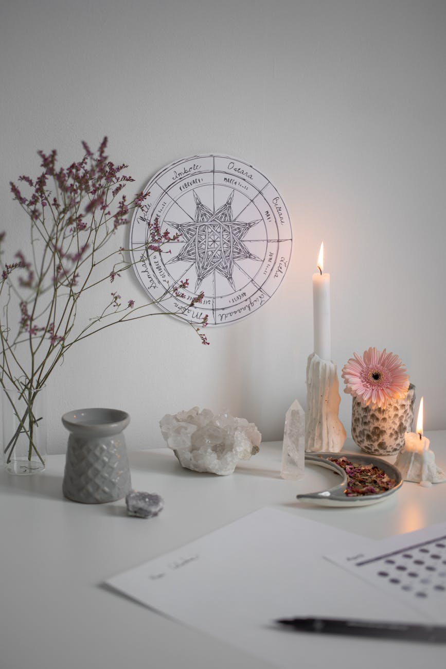 burning candle and crystals by wheel of year on wall