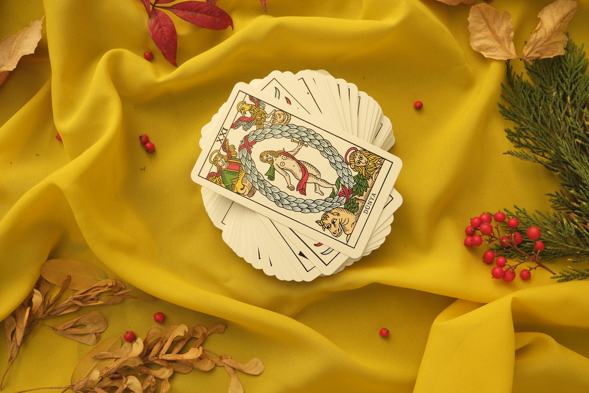 deck of tarot cards lying on yellow fabric