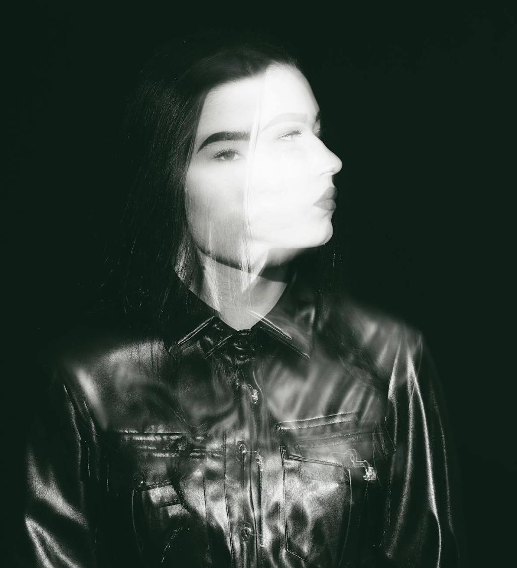 a grayscale of a woman turning her head