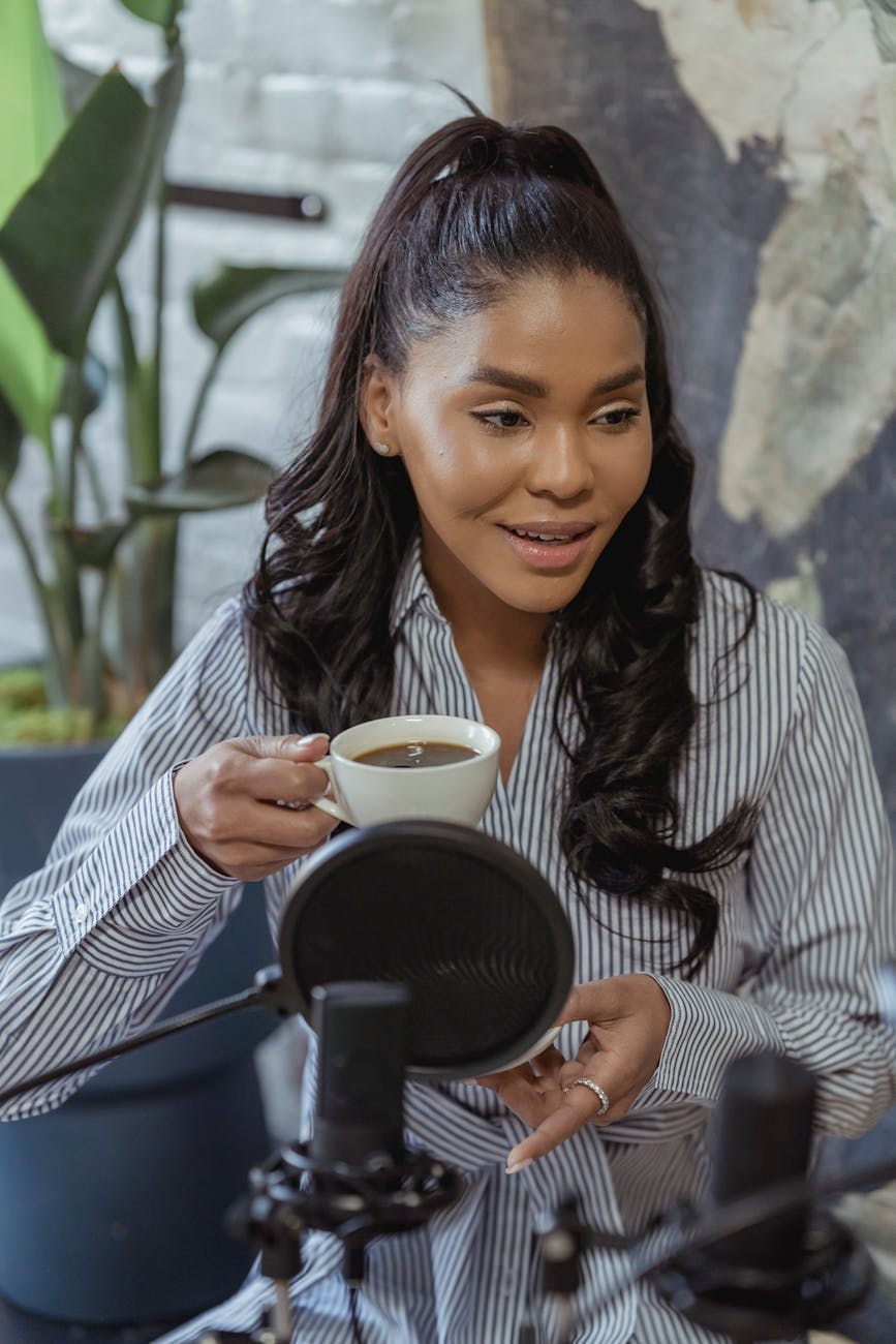 a woman in a striped shirt having a cup of coffee