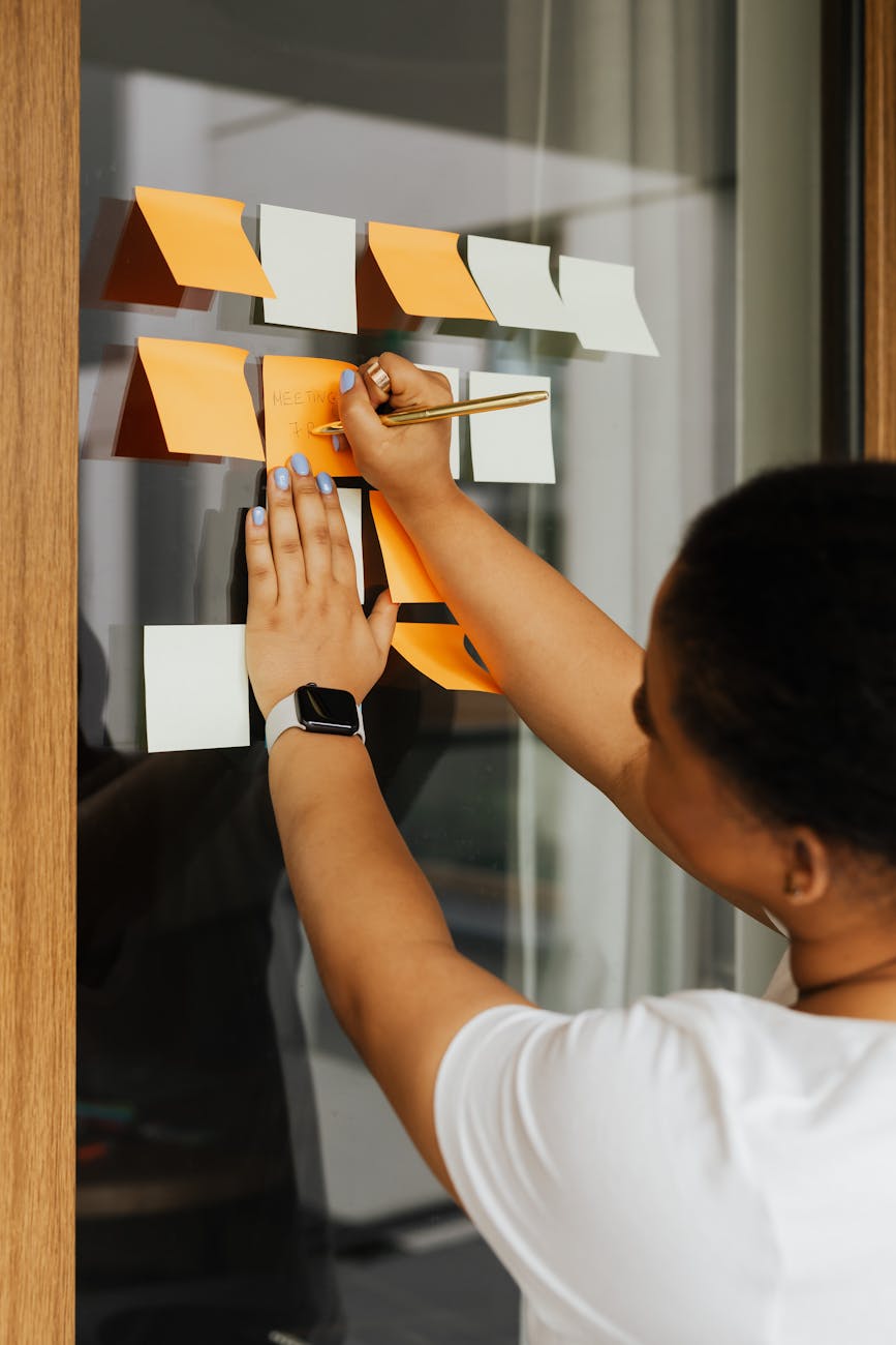 woman writing notes on memo sticky note