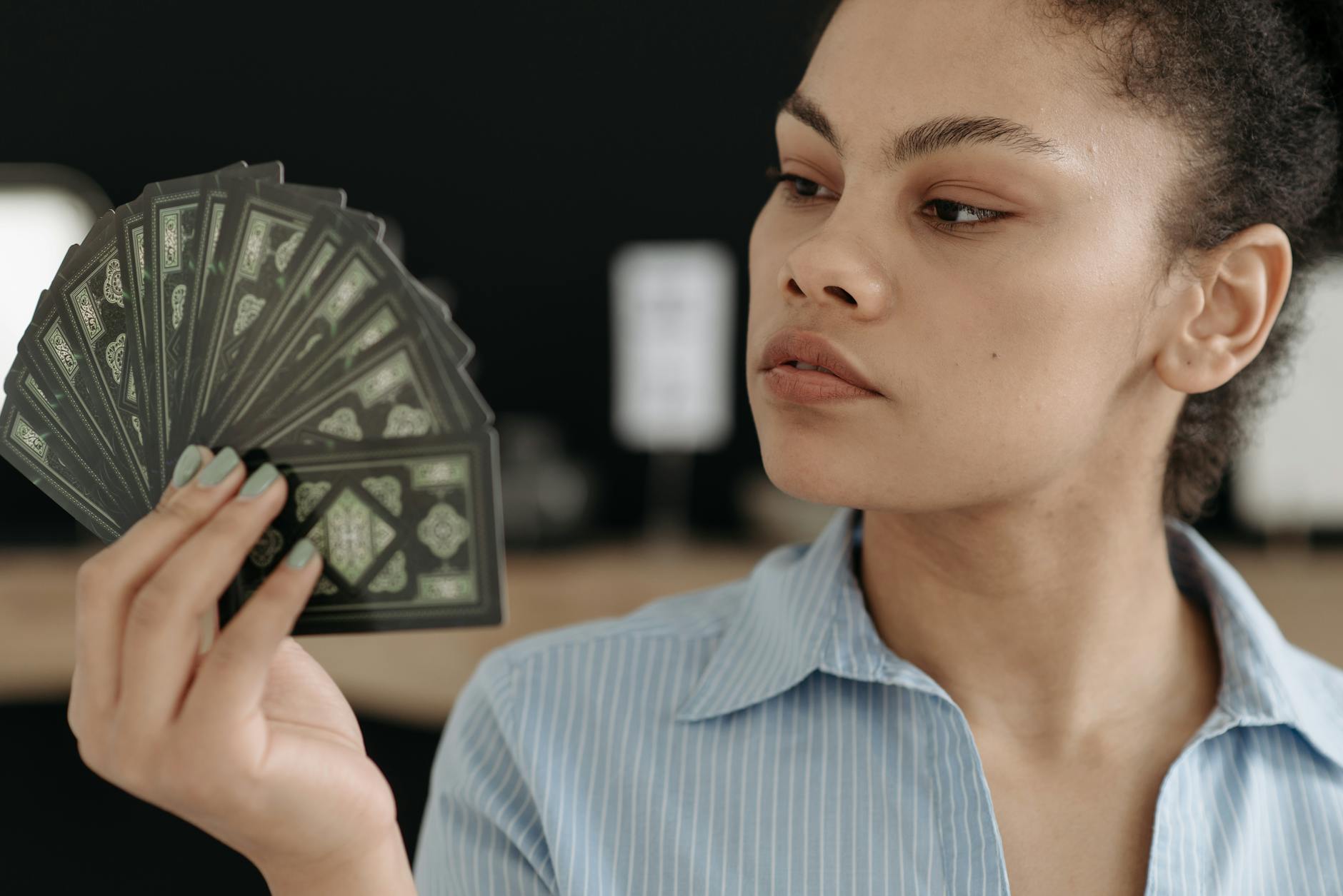woman looking at a deck of cards in her hand