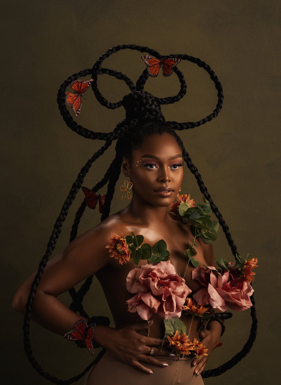 woman posing with flowers on body and dreadlocks hairstyle